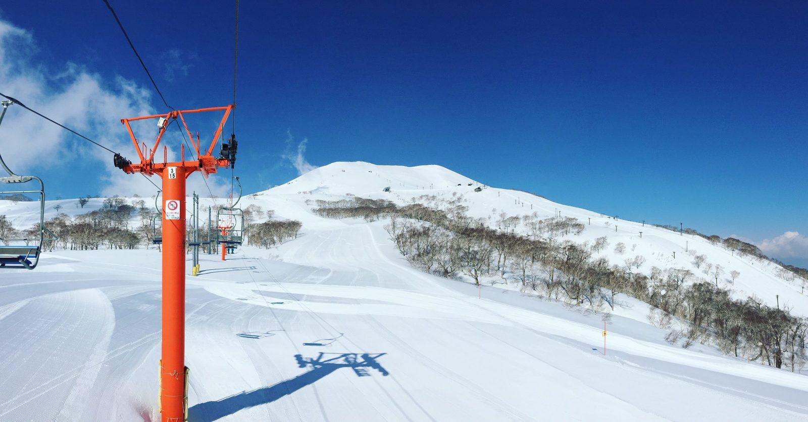 二世古清晨第一道雪痕，整壓雪道與晴空下的吊椅纜車